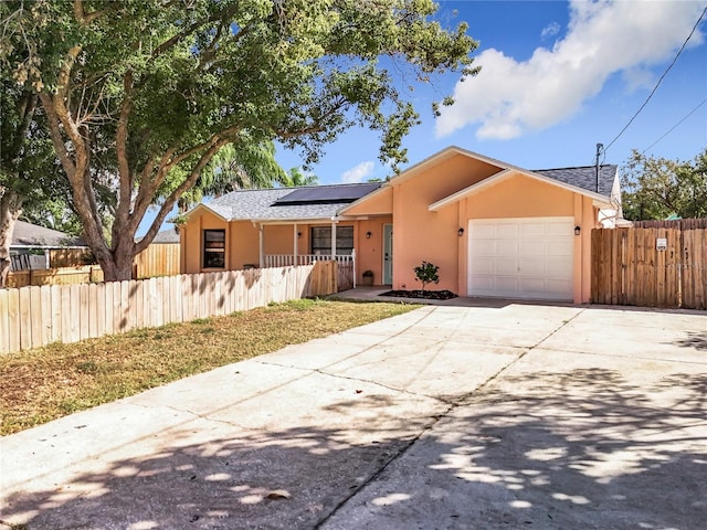 single story home with solar panels and a garage