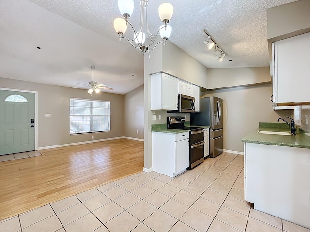 kitchen featuring stainless steel appliances, sink, light wood-type flooring, white cabinetry, and a textured ceiling