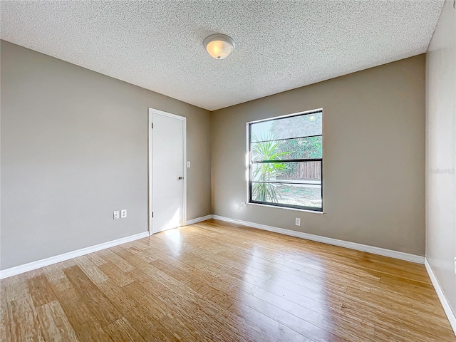 spare room featuring a textured ceiling and light wood-type flooring