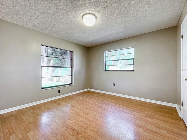 unfurnished room featuring a textured ceiling and light hardwood / wood-style flooring