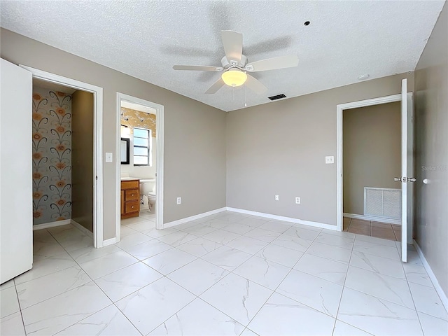 unfurnished bedroom with connected bathroom, ceiling fan, and a textured ceiling