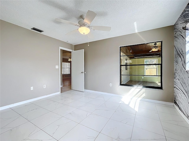 spare room with a textured ceiling and ceiling fan