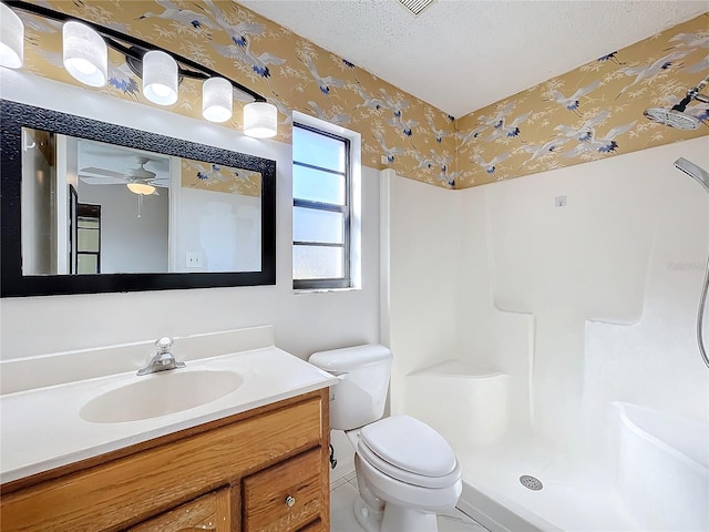 bathroom featuring toilet, walk in shower, vanity, a textured ceiling, and ceiling fan