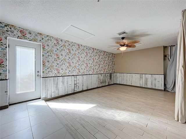 spare room featuring light hardwood / wood-style floors, a textured ceiling, and ceiling fan