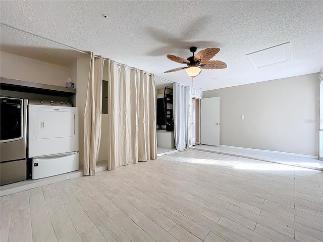 clothes washing area featuring washing machine and dryer, a textured ceiling, light wood-type flooring, and ceiling fan