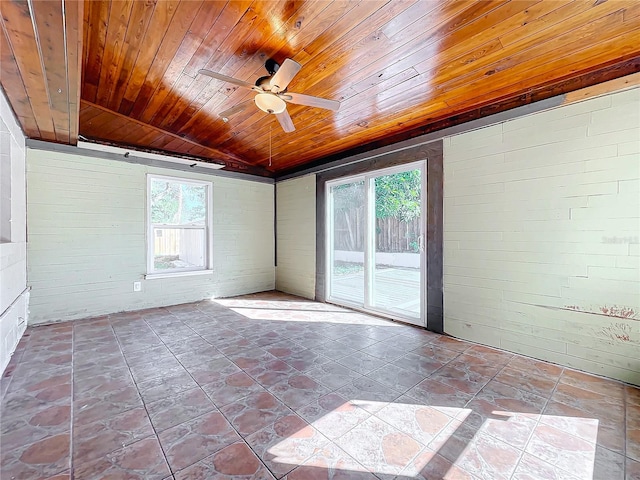 spare room featuring lofted ceiling, ceiling fan, brick wall, and wooden ceiling