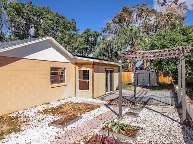 rear view of property with a patio, a pergola, and a storage shed