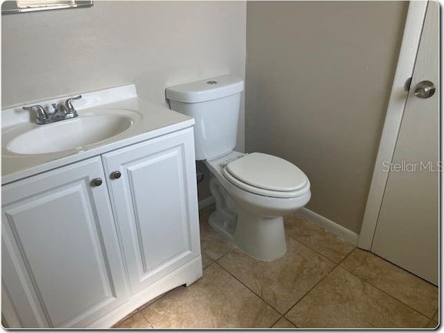 bathroom with vanity, toilet, and tile patterned flooring