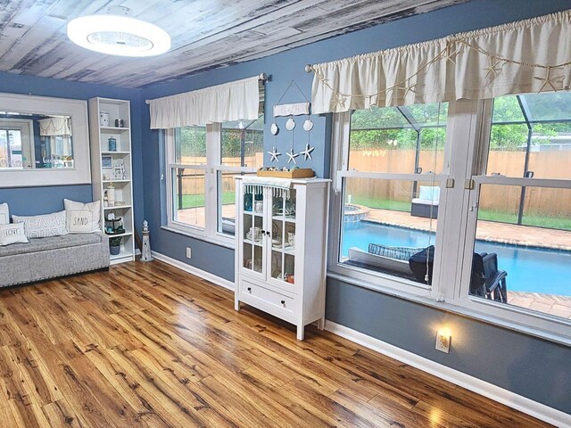 unfurnished sunroom featuring a healthy amount of sunlight and wooden ceiling