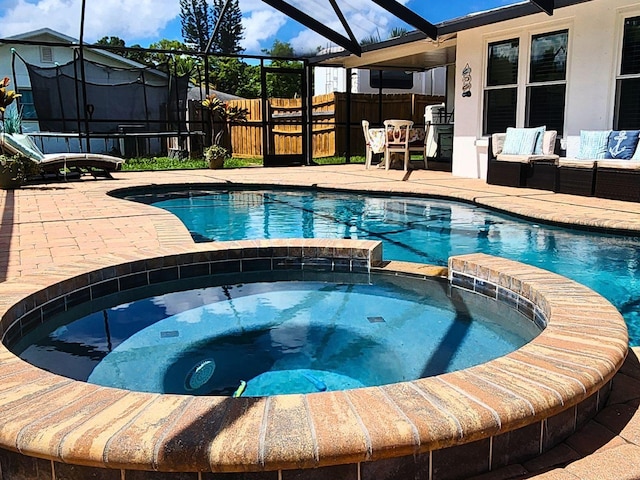 view of pool featuring outdoor lounge area, a patio area, and an in ground hot tub