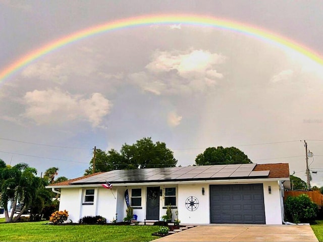 single story home featuring solar panels, a garage, and a front yard