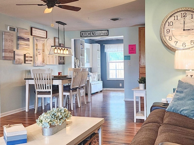 living room with ceiling fan and dark wood-type flooring