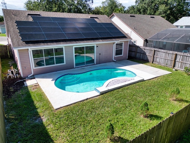 view of swimming pool with a yard, a patio, and a lanai