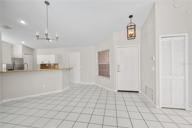 interior space with light tile patterned floors, baseboards, visible vents, and a chandelier