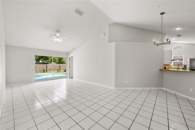 unfurnished living room with visible vents, ceiling fan with notable chandelier, a sink, light tile patterned floors, and lofted ceiling