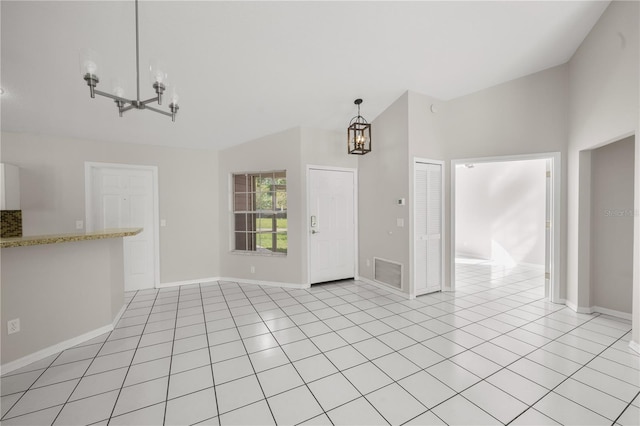 unfurnished living room with visible vents, light tile patterned floors, baseboards, a chandelier, and vaulted ceiling