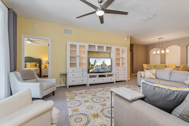 living room with light carpet and ceiling fan with notable chandelier