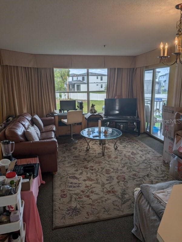 living room with an inviting chandelier and carpet flooring