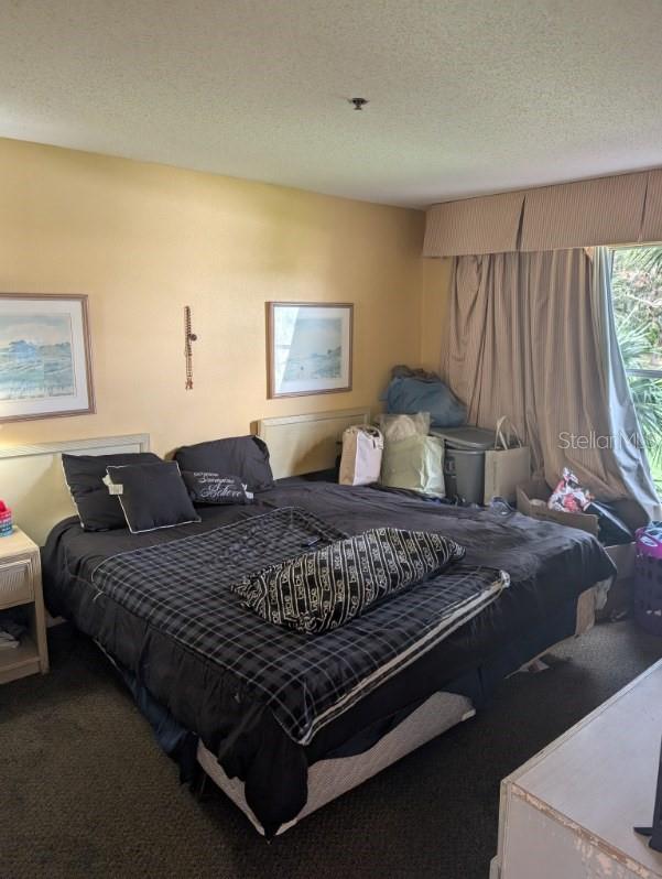 bedroom featuring carpet and a textured ceiling