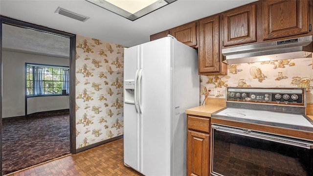 kitchen featuring electric range oven, white refrigerator with ice dispenser, and light parquet flooring