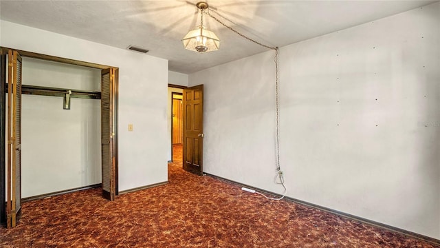 unfurnished bedroom featuring a closet and dark colored carpet