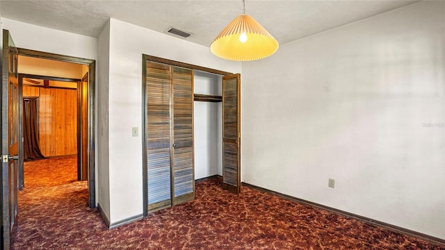 unfurnished bedroom with a closet and carpet floors