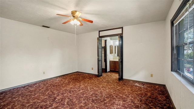 carpeted empty room featuring ceiling fan