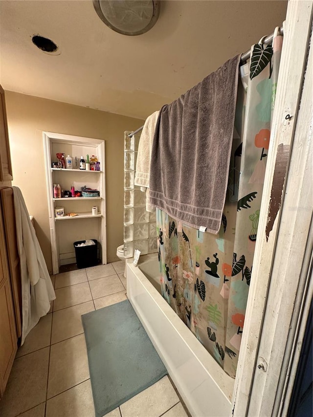 bathroom with toilet, tile patterned floors, and shower / bath combo with shower curtain