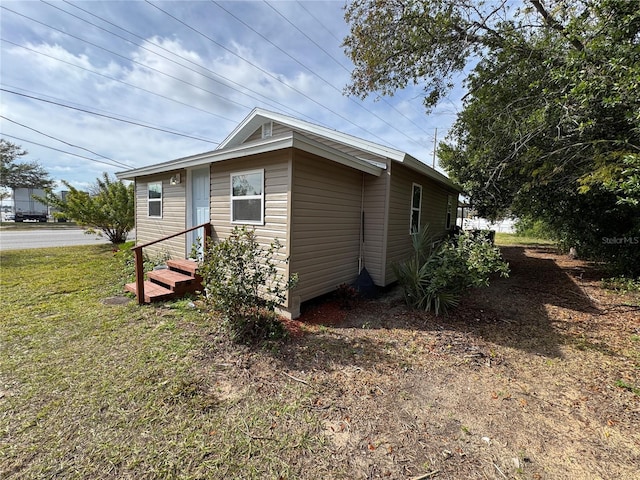 view of side of home with a yard