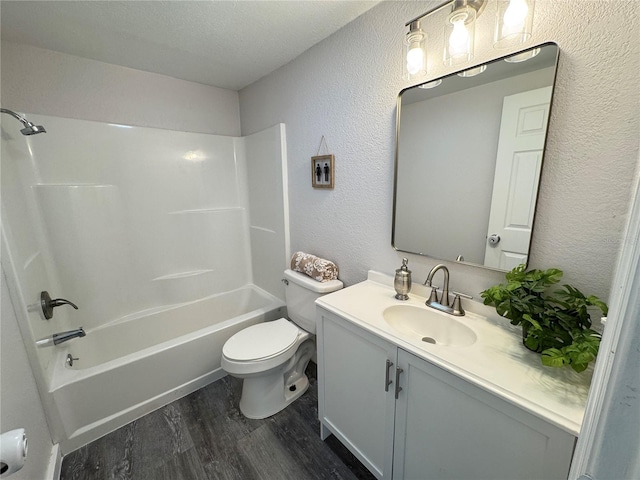 full bathroom with wood-type flooring, vanity, toilet, bathing tub / shower combination, and a textured ceiling