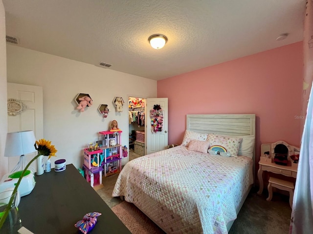 carpeted bedroom featuring a walk in closet, a textured ceiling, and a closet