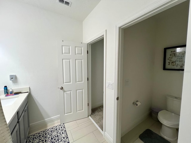 bathroom featuring toilet, vanity, and tile patterned flooring