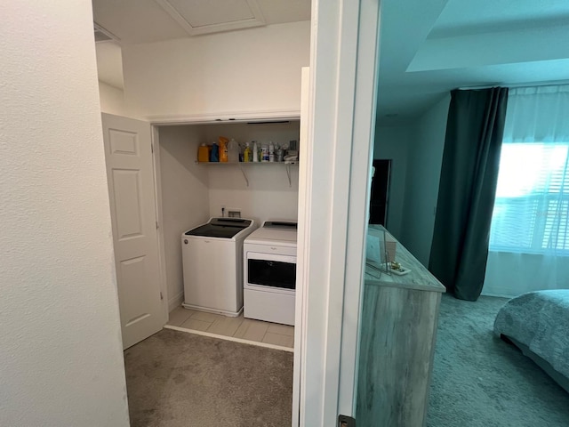 clothes washing area with light carpet and washer and clothes dryer