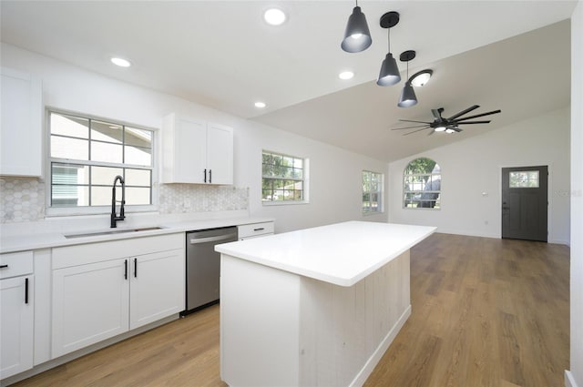 kitchen featuring white cabinets, tasteful backsplash, dishwasher, sink, and a center island