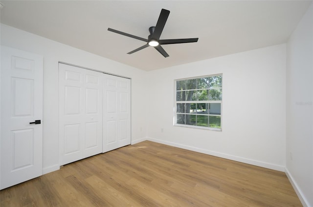 unfurnished bedroom with a closet, light hardwood / wood-style floors, and ceiling fan