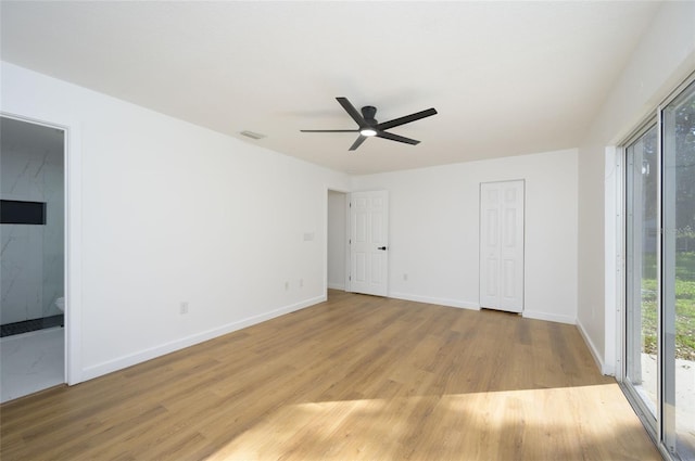 unfurnished bedroom featuring connected bathroom, ceiling fan, light hardwood / wood-style flooring, and access to exterior