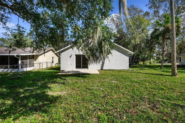 back of property with a yard and a patio