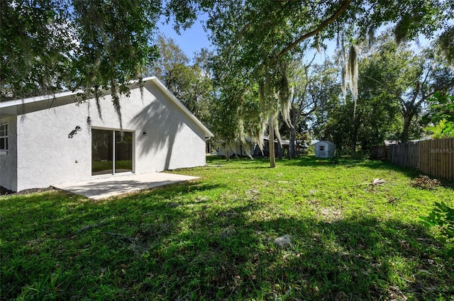 view of yard with a patio and a storage shed