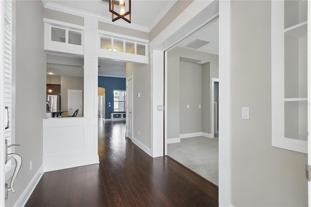 entryway featuring ornamental molding, dark wood-type flooring, and baseboards