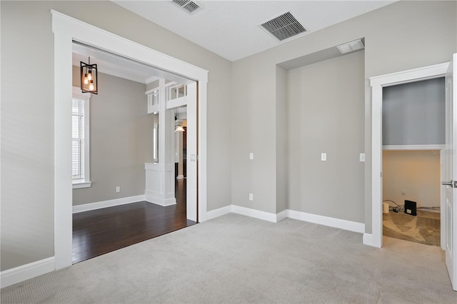 carpeted spare room featuring visible vents and baseboards