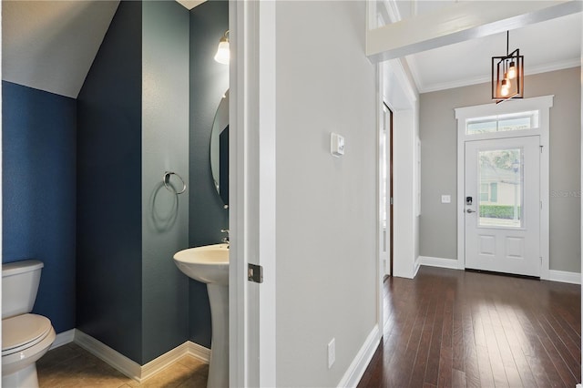 foyer with baseboards, dark wood finished floors, and crown molding