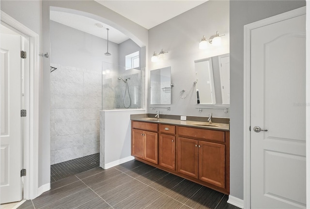 bathroom with a walk in shower, double vanity, and a sink