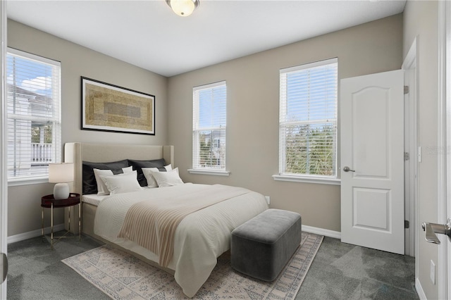 bedroom featuring dark carpet and baseboards