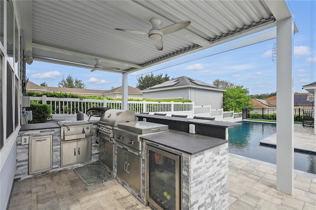 view of patio featuring ceiling fan, a fenced backyard, outdoor wet bar, area for grilling, and a fenced in pool