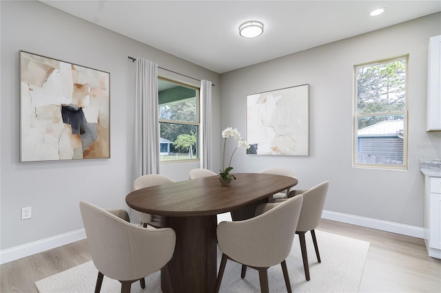 dining area with light wood-type flooring and a wealth of natural light