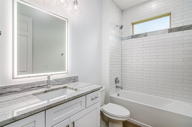 full bathroom featuring vanity, tiled shower / bath combo, and toilet