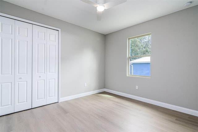 unfurnished bedroom featuring light wood-type flooring, a closet, and ceiling fan