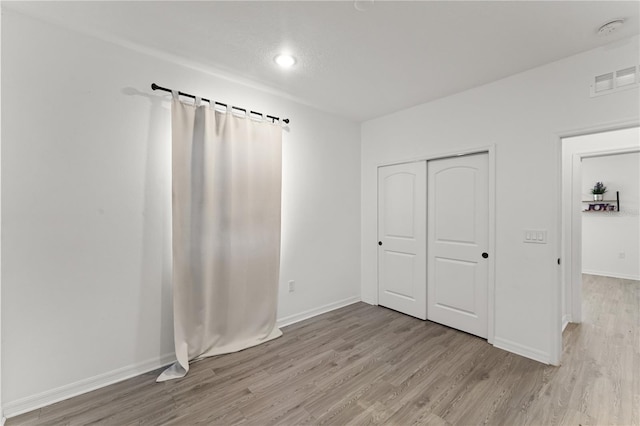 unfurnished bedroom featuring a closet and light hardwood / wood-style flooring