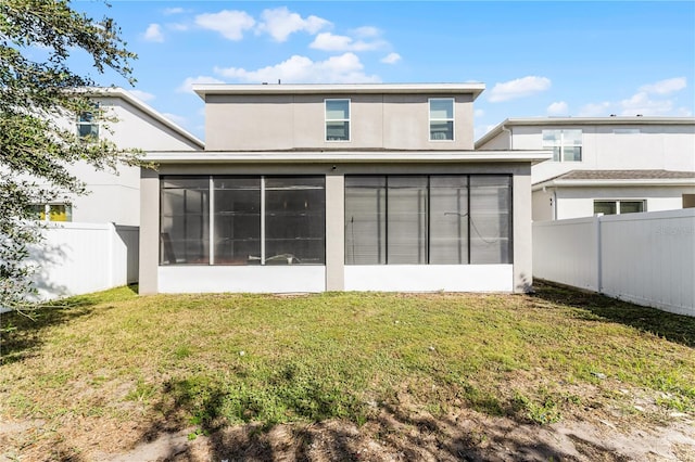 back of property with a sunroom and a yard