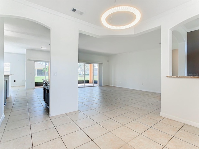 unfurnished room featuring crown molding, light tile patterned floors, and plenty of natural light